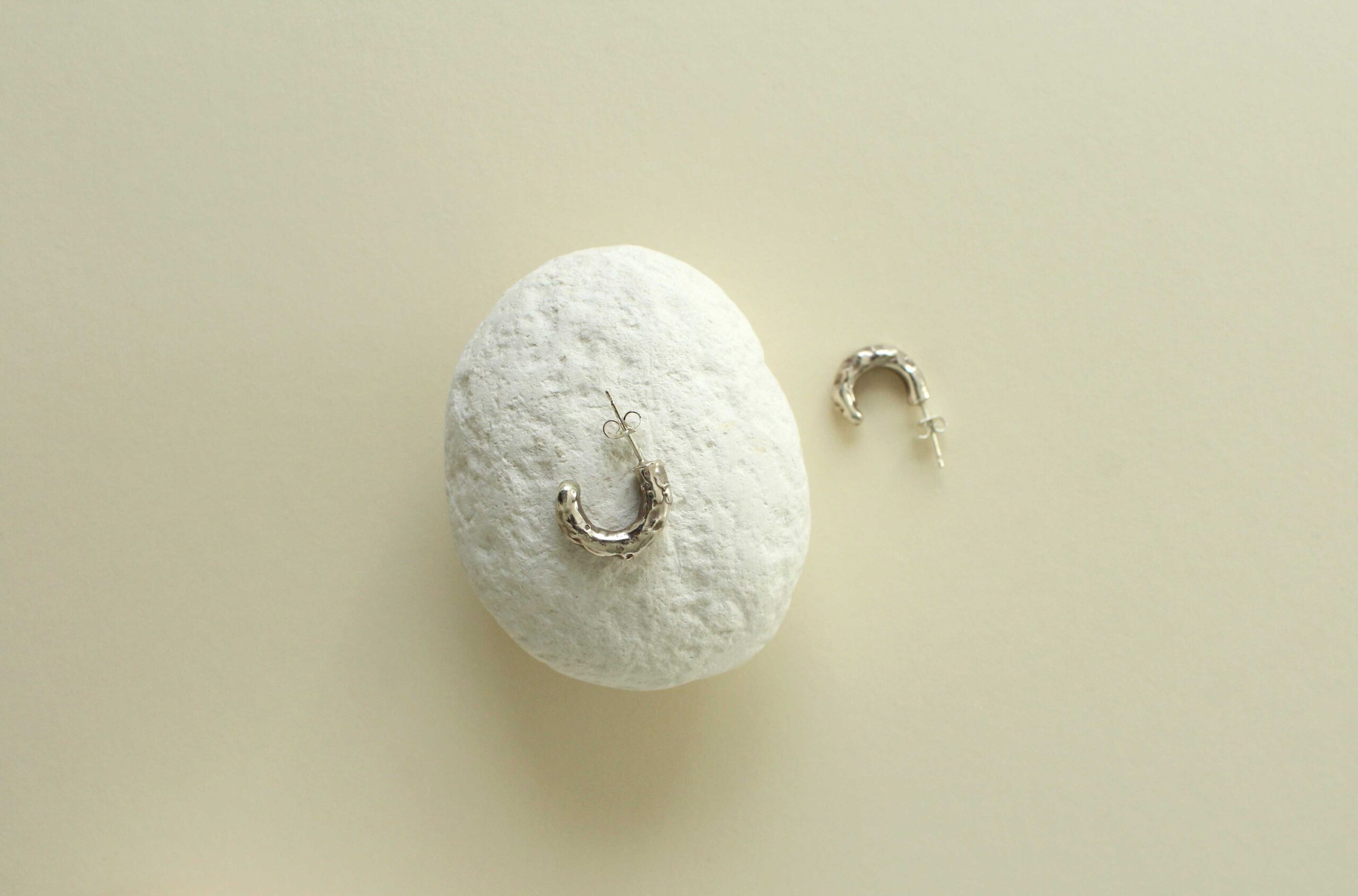 Earrings on white stone pebble